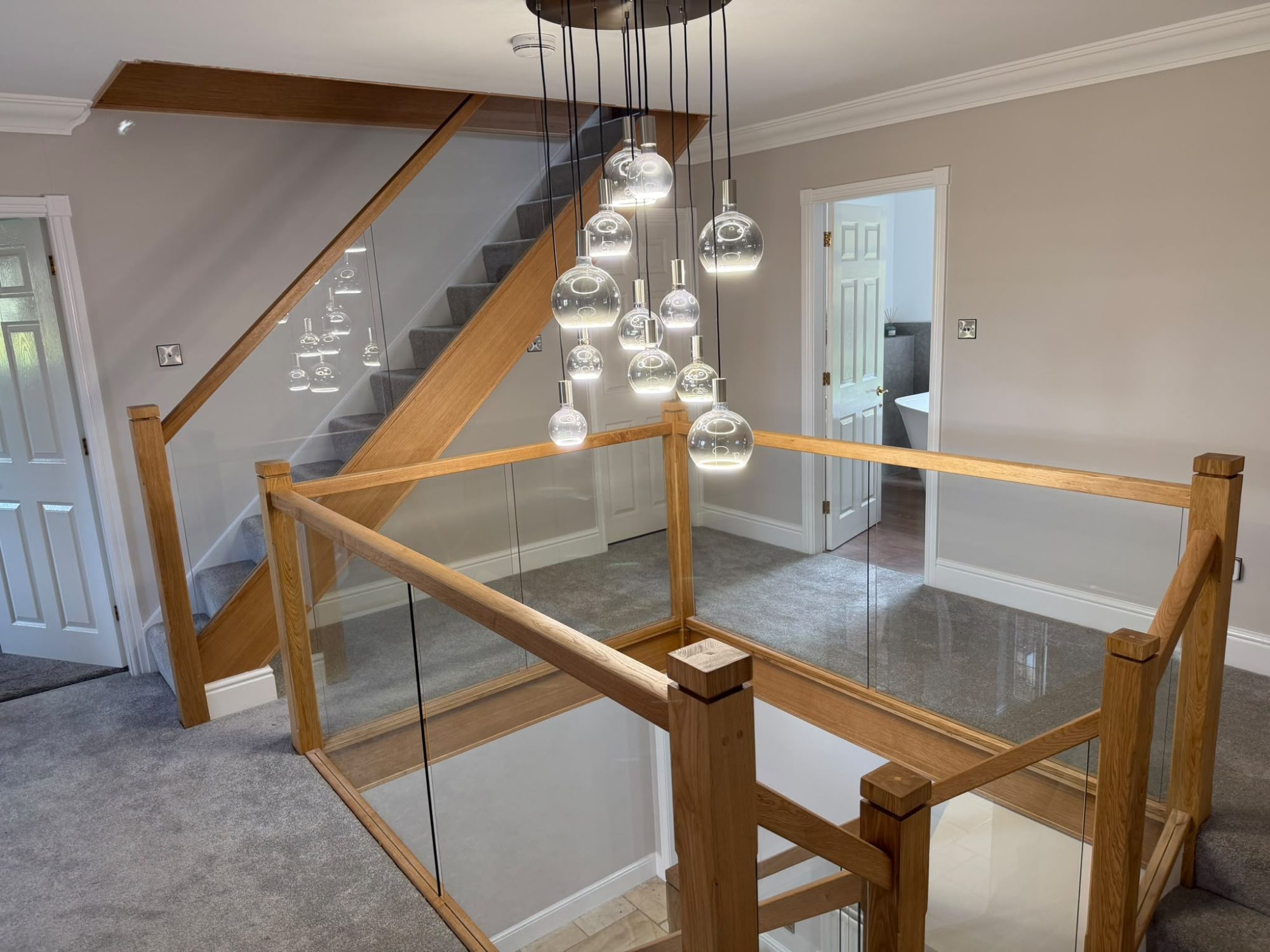 Modern interior showcasing glass balustrades with timber base and handrails