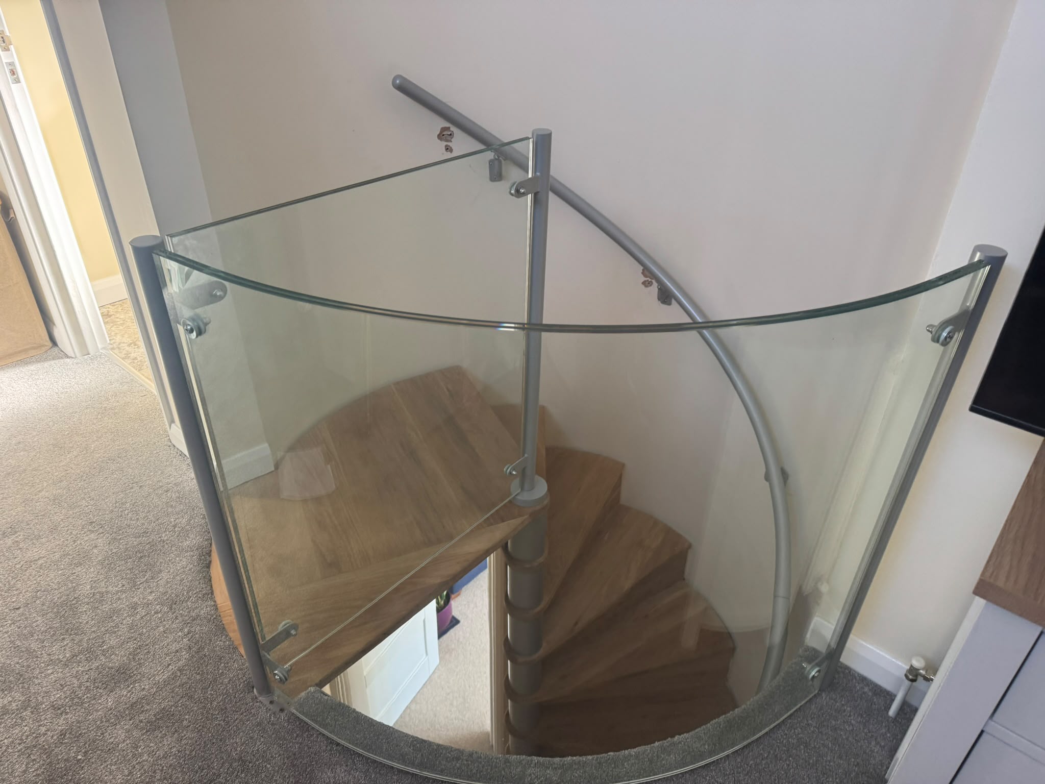 Spiral stairs with metal details and glass balustrade