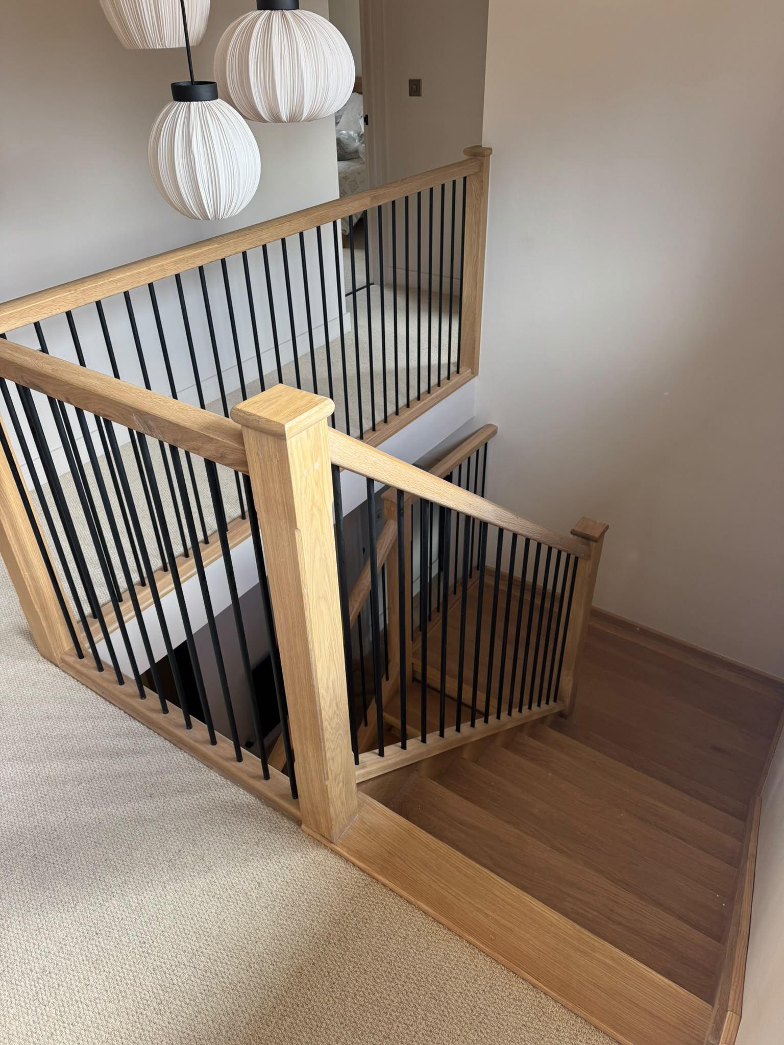 Modern residential staircase featuring glass panels and black iron poles